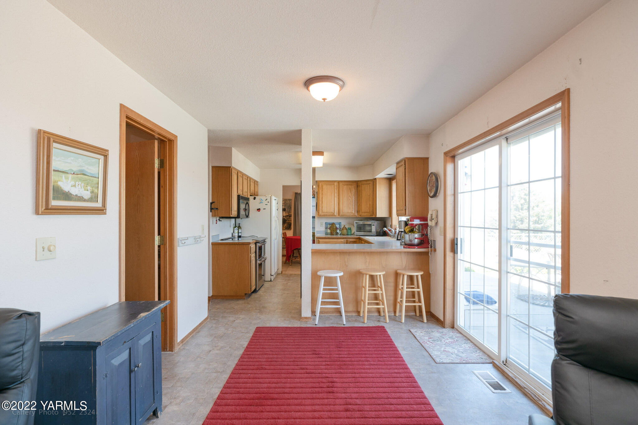 3870 Aaron Road Moxee, WA 98936 - Photo 20 of 33 a open kitchen with stainless steel appliances granite countertop a refrigerator a stove a sink dishwasher and white cabinets with wooden floor next to windows