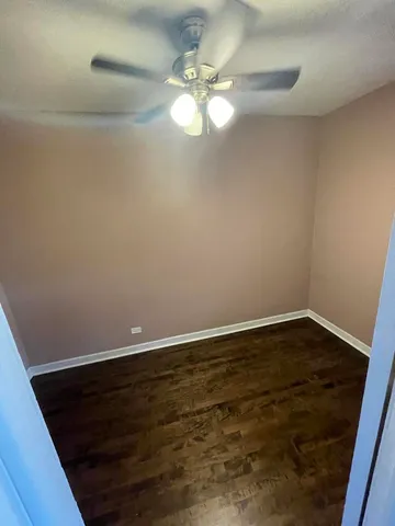 a view of a room with wooden floor and fan