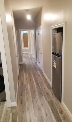 a view of a hallway with wooden floor