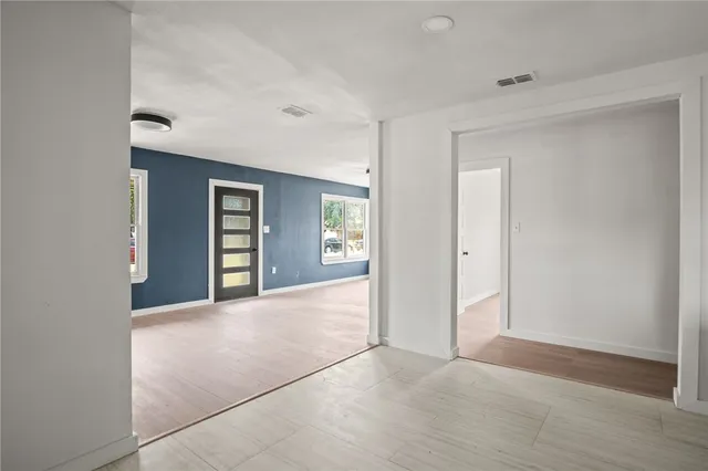 a view of an empty room with closet and bathroom