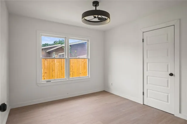 an empty room with a window and wooden floor