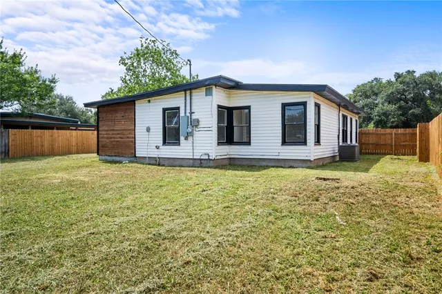 a front view of house with yard and trees in the background