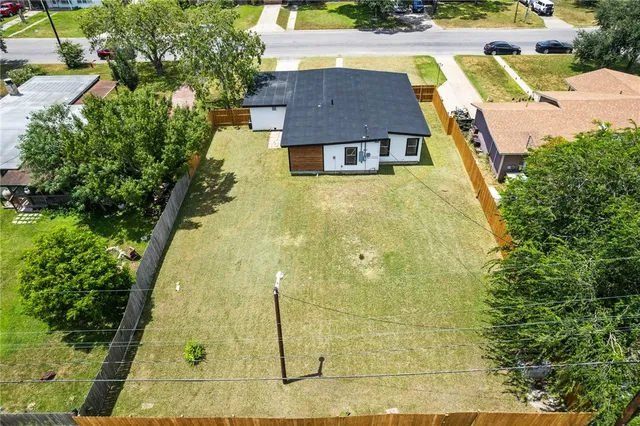 a aerial view of a house with swimming pool and large trees