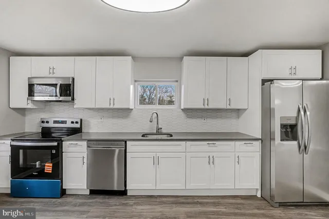 a kitchen with white cabinets and stainless steel appliances