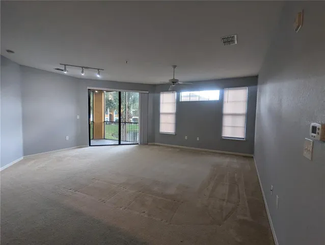 an empty room with windows and chandelier