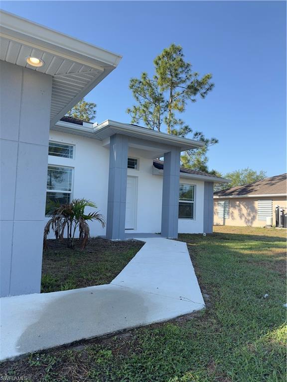 3707 38th Street Southwest Lehigh Acres, FL 33976 - Photo 2 of 16 Doorway to property with a yard