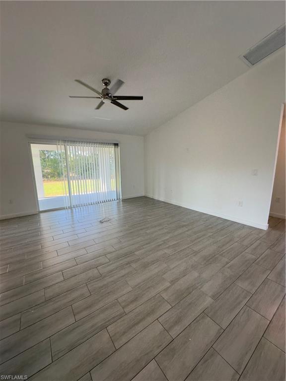 3707 38th Street Southwest Lehigh Acres, FL 33976 - Photo 6 of 16 Spare room with wood tiled floors and a ceiling fan