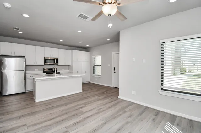 a kitchen with stainless steel appliances a stove sink microwave and cabinets
