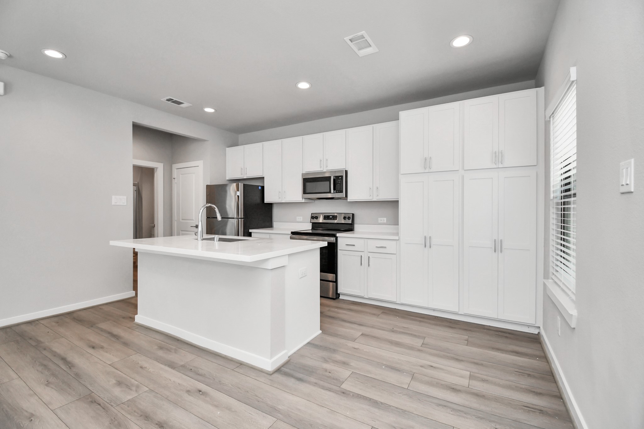 a kitchen with white cabinets and stainless steel appliances