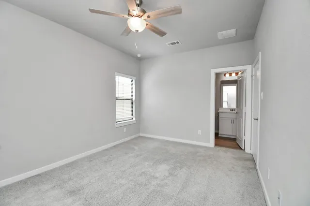 a view of an empty room with a chandelier fan