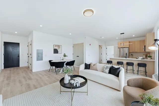 a living room with furniture and a view of kitchen