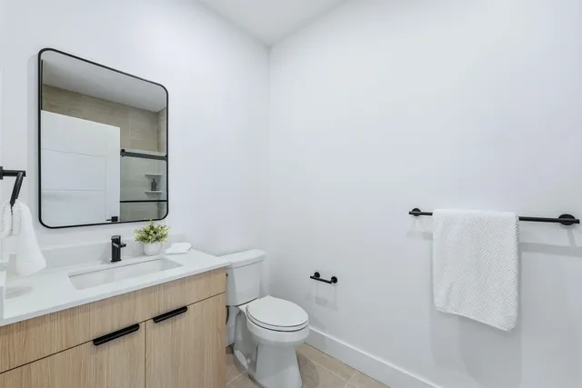 a bathroom with a toilet sink and mirror