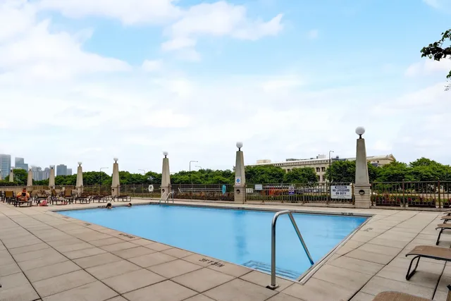 a view of swimming pool with lawn chairs
