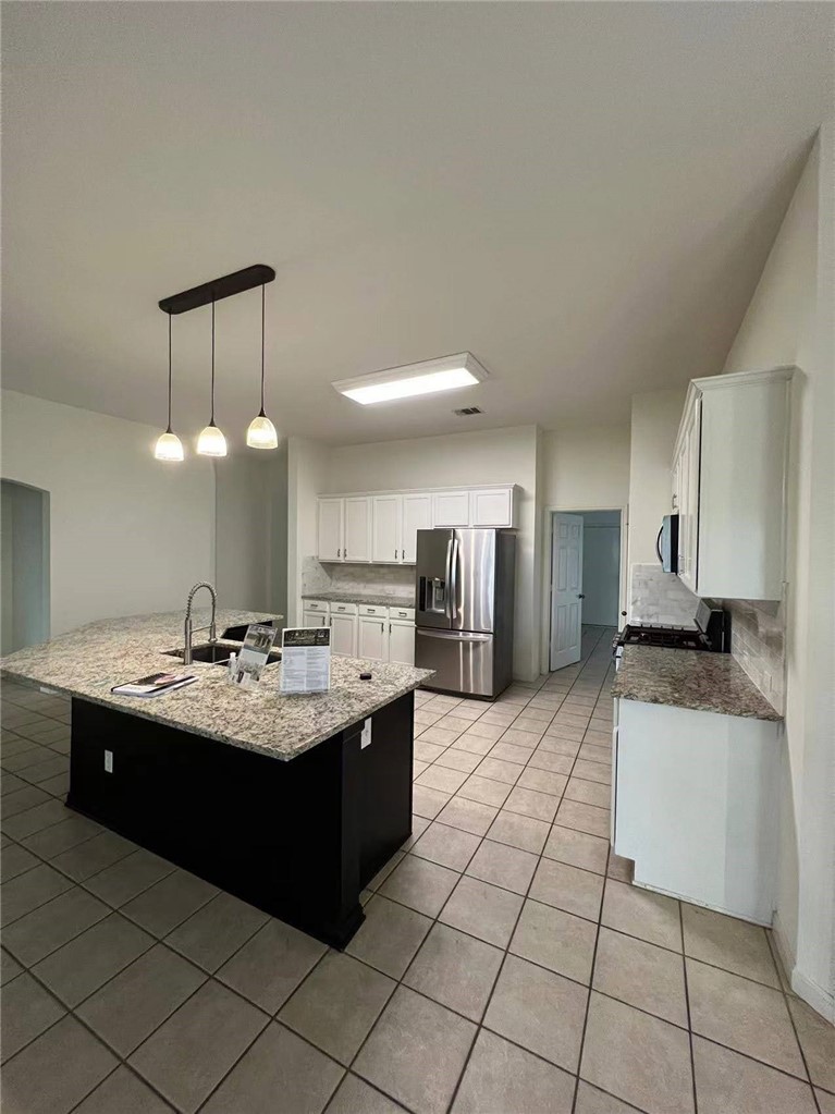 507 Red Hawk Drive Leander, TX 78641 - Photo 5 of 14 a kitchen with stainless steel appliances kitchen island granite countertop a sink and cabinets