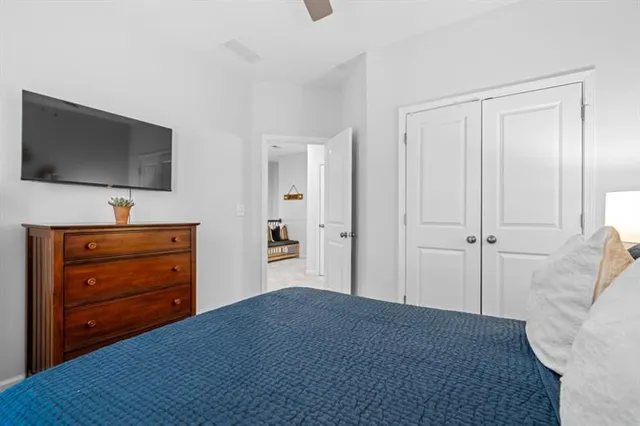 a spacious bedroom with a bed a dresser and a chandelier