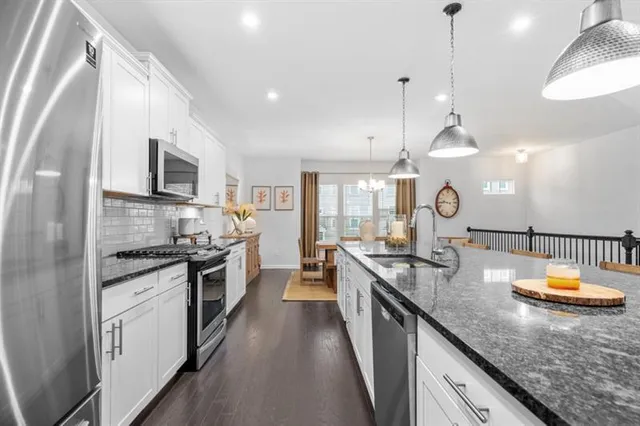 a kitchen with stainless steel appliances granite countertop wooden cabinets a stove top oven a sink and dishwasher