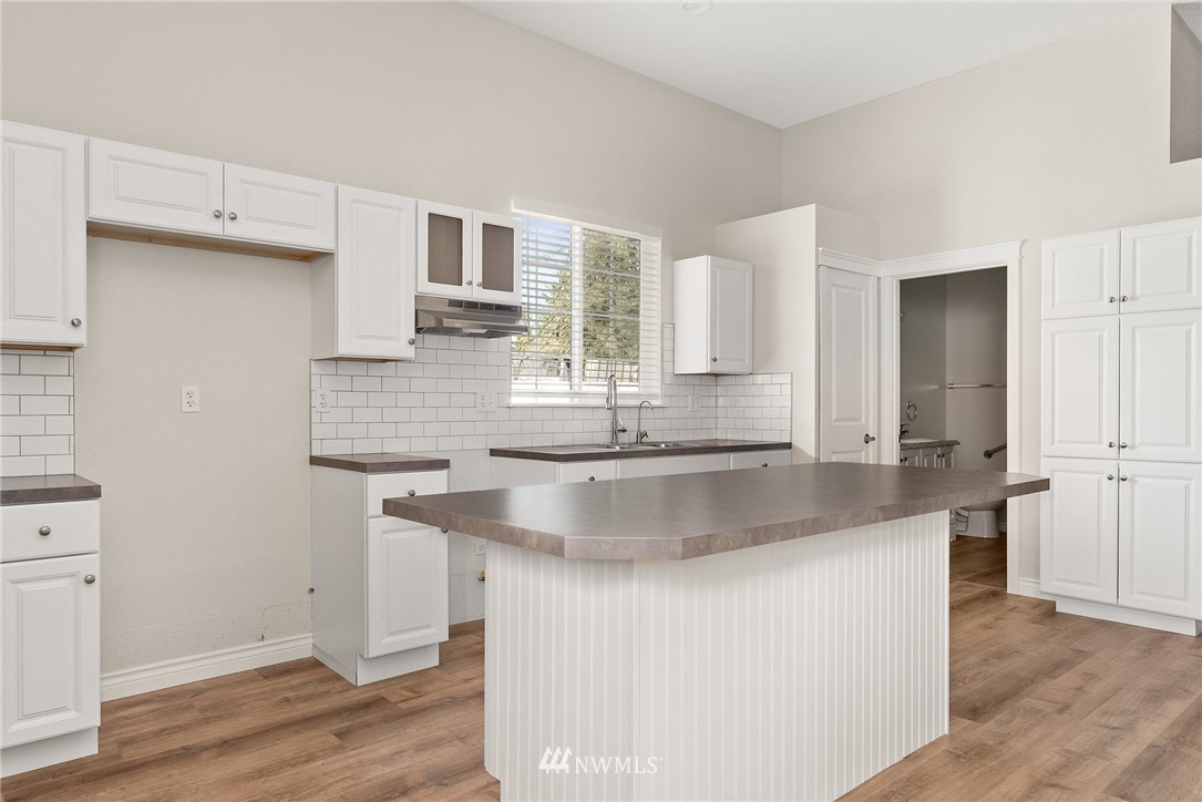 18622 Melon Street Southwest Rochester, WA 98579 - Photo 26 of 33 a kitchen with kitchen island granite countertop a sink and a stove top oven