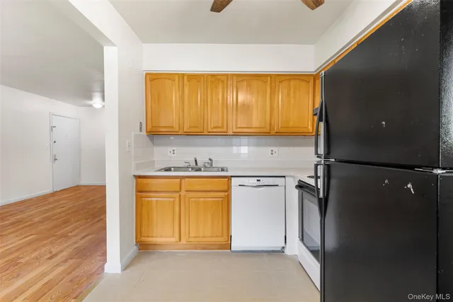 a kitchen with stainless steel appliances granite countertop a refrigerator a stove a sink and dishwasher with a dishwasher