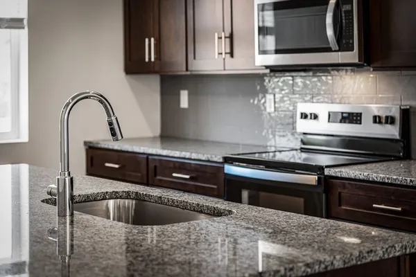 a kitchen with granite countertop a sink and a stove