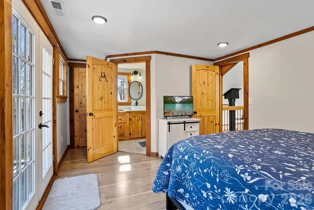 a spacious bedroom with a bed and a dresser next to a window