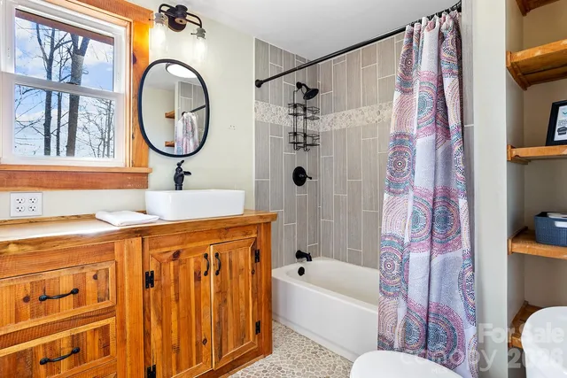 a bathroom with a sink a mirror a bathtub and a shower