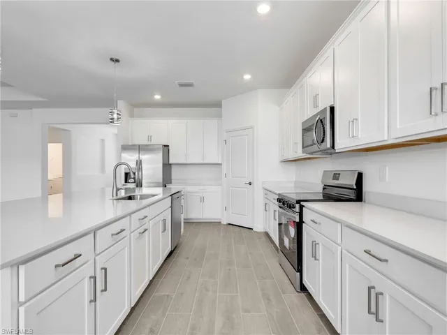 a kitchen with white cabinets sink and stove