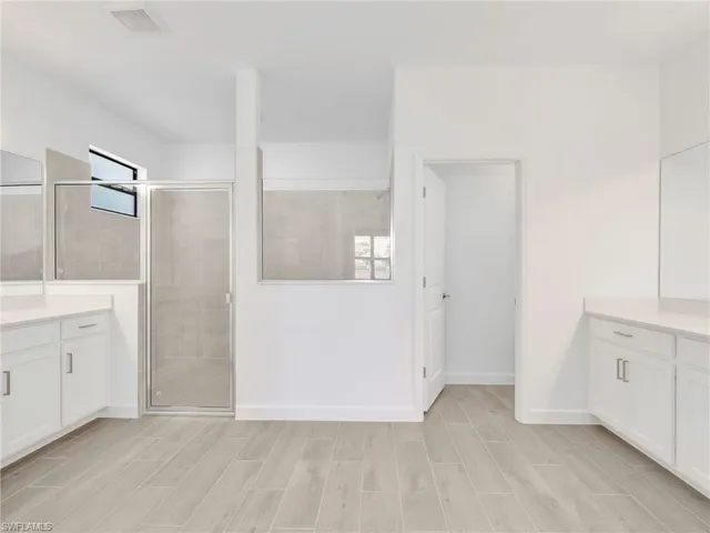 an empty room with white cabinet and mirror