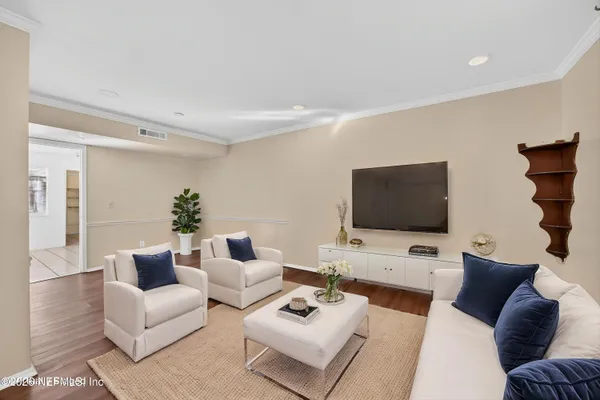 a living room with furniture a flat screen tv and a window