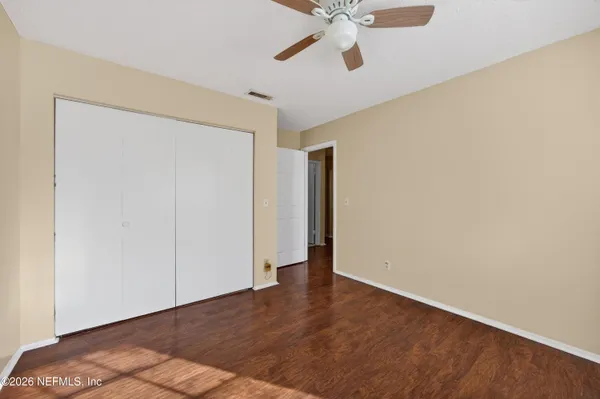 a view of an empty room with wooden floor