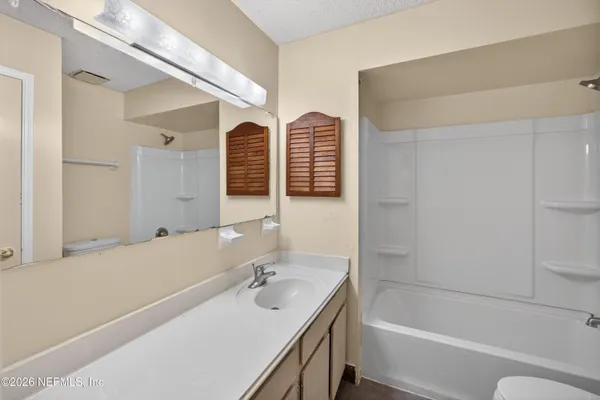 a bathroom with a tub sink and mirror