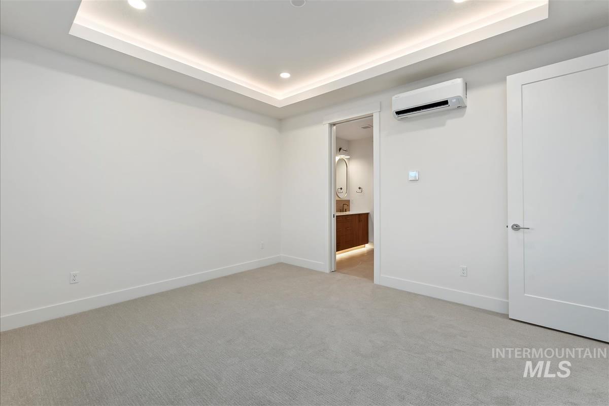 3213 West Moore Street Boise, ID 83702 - Photo 17 of 32 Recessed lighting and cove lighting illuminate a neutral-toned room with light gray carpeting