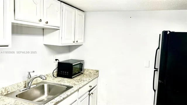 a kitchen with a sink and a refrigerator