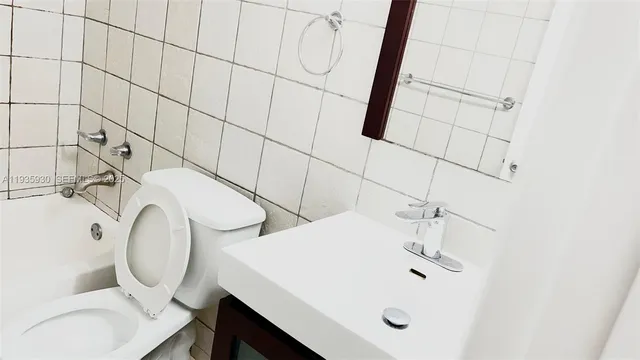 a bathroom with a sink and mirror with toilet