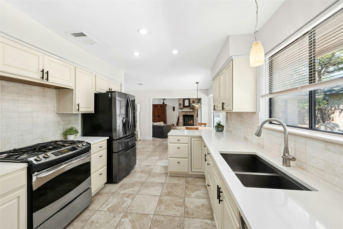 6906 Bayridge Terrace Austin, TX 78759 - Photo 11 of 35 a kitchen with a sink a refrigerator and a stove