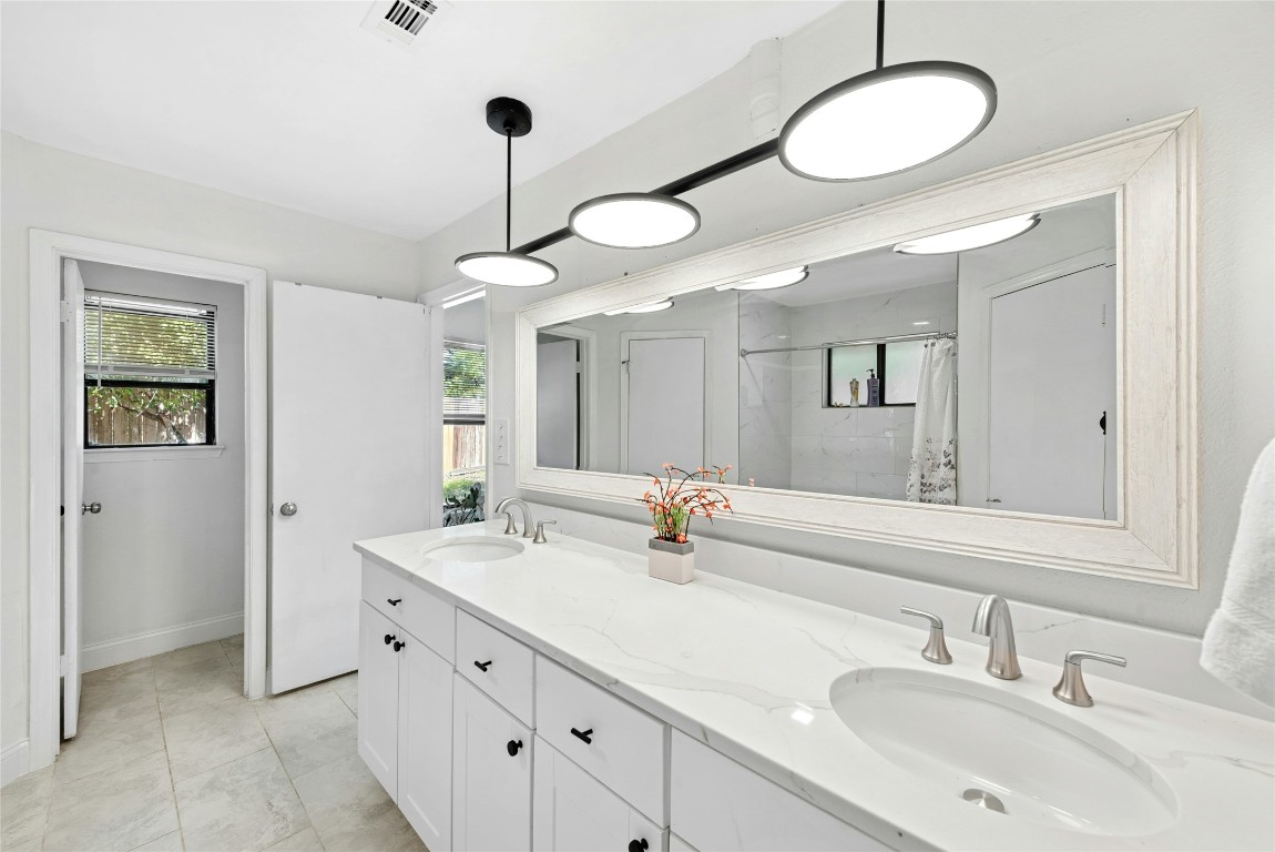 6906 Bayridge Terrace Austin, TX 78759 - Photo 22 of 35 a bathroom with a sink vanity and a mirror