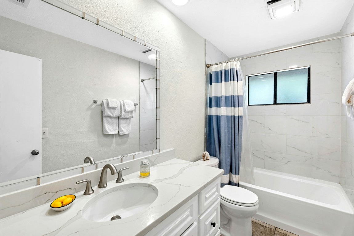6906 Bayridge Terrace Austin, TX 78759 - Photo 27 of 35 a bathroom with a granite countertop sink and a mirror