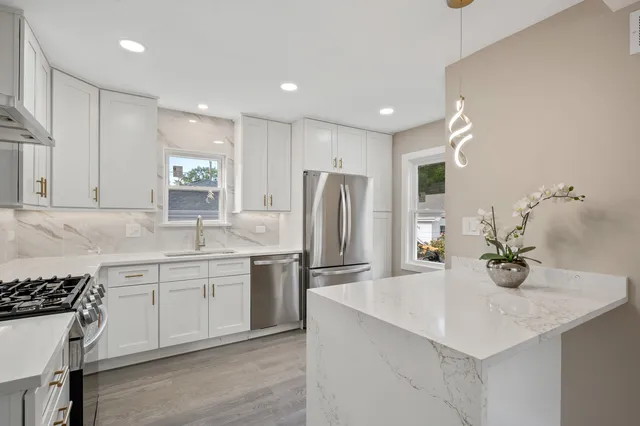 a kitchen with stainless steel appliances a sink stove and refrigerator