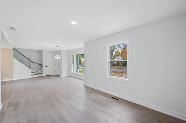 an empty room with windows and wooden floor