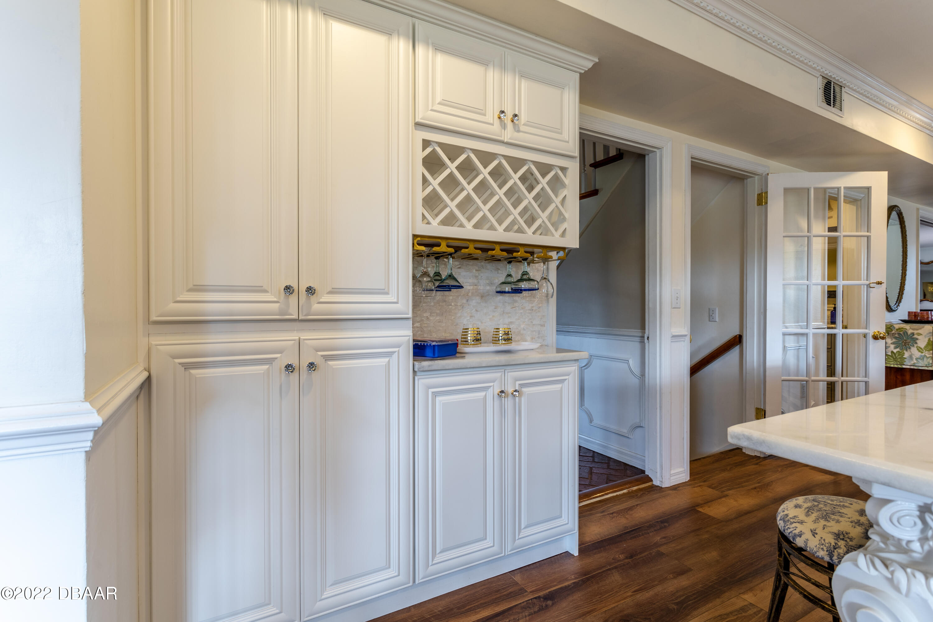 82 North St Andrews Drive Ormond Beach, FL 32174 - Photo 17 of 60 a kitchen with white cabinets and wooden floor
