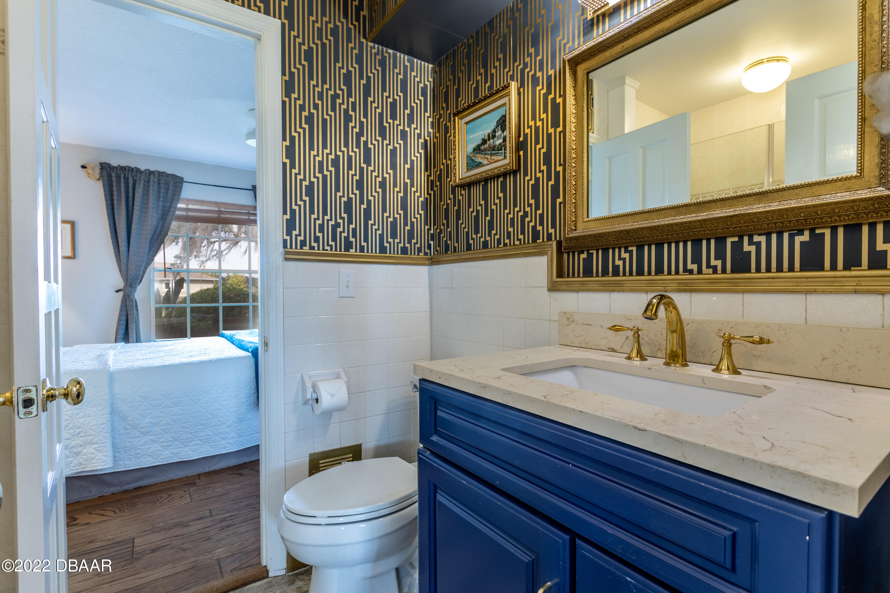 82 North St Andrews Drive Ormond Beach, FL 32174 - Photo 24 of 60 a bathroom with a granite countertop toilet sink and a mirror