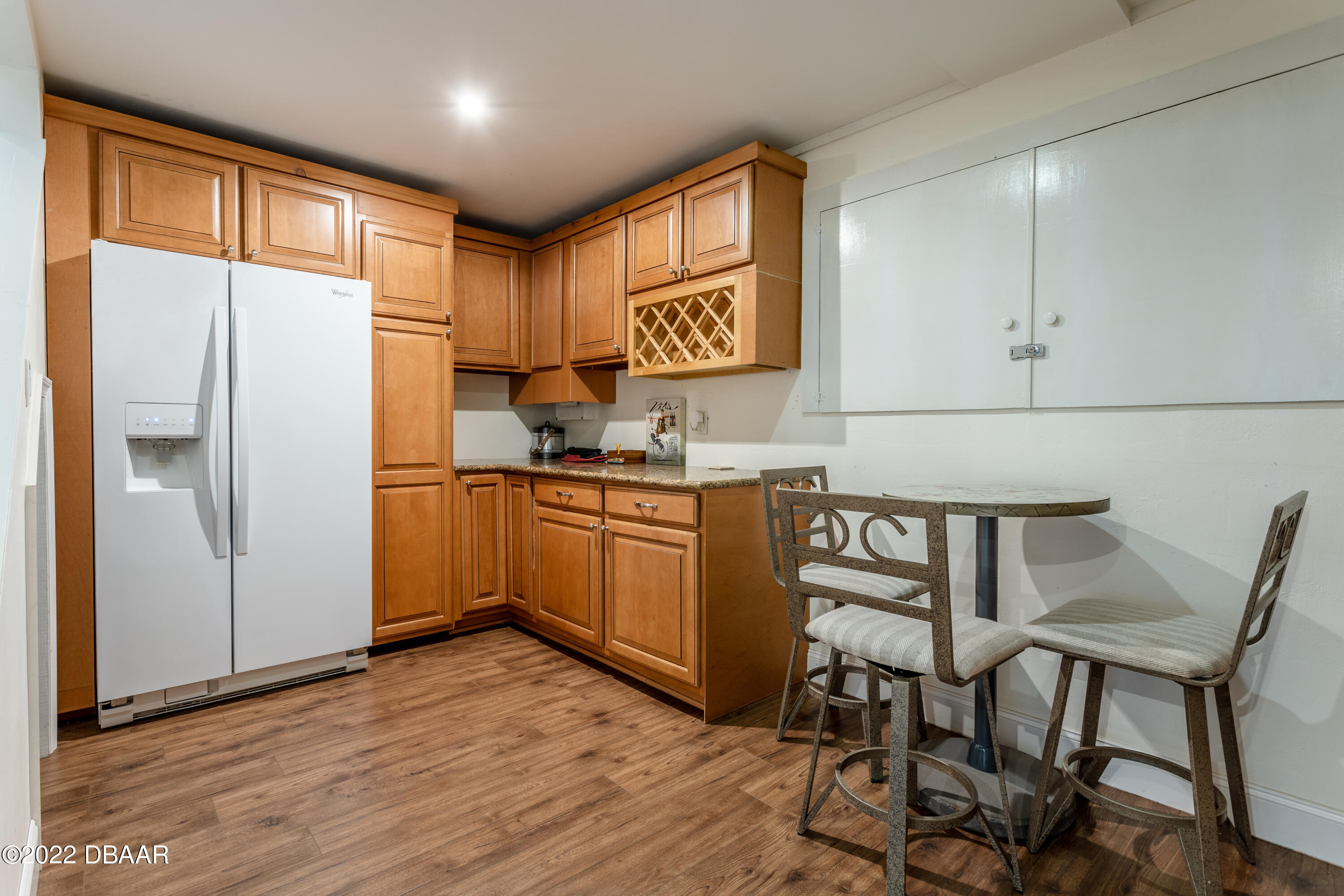 82 North St Andrews Drive Ormond Beach, FL 32174 - Photo 32 of 60 a kitchen with cabinets wooden floor and a refrigerator