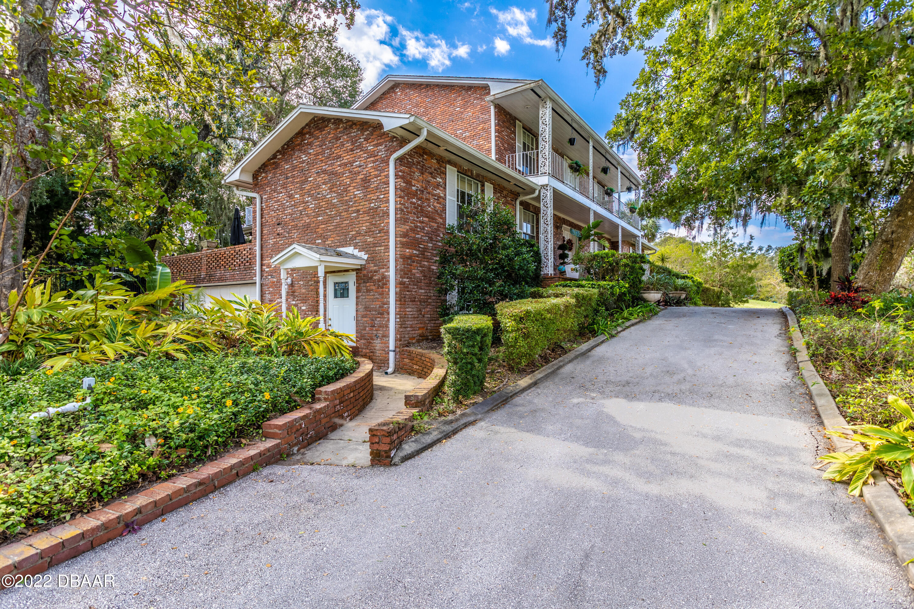 82 North St Andrews Drive Ormond Beach, FL 32174 - Photo 4 of 60 a front view of a house with a yard and potted plants