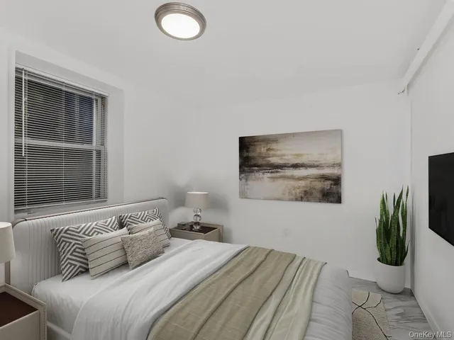 a bedroom with a bed a couch and potted plant