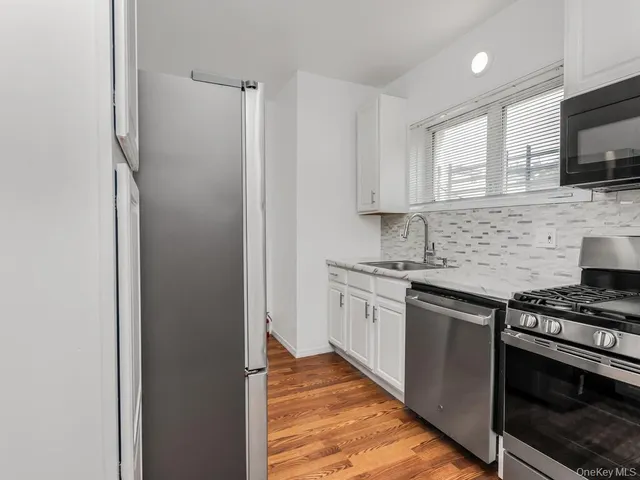 a kitchen with stainless steel appliances a sink stove and microwave