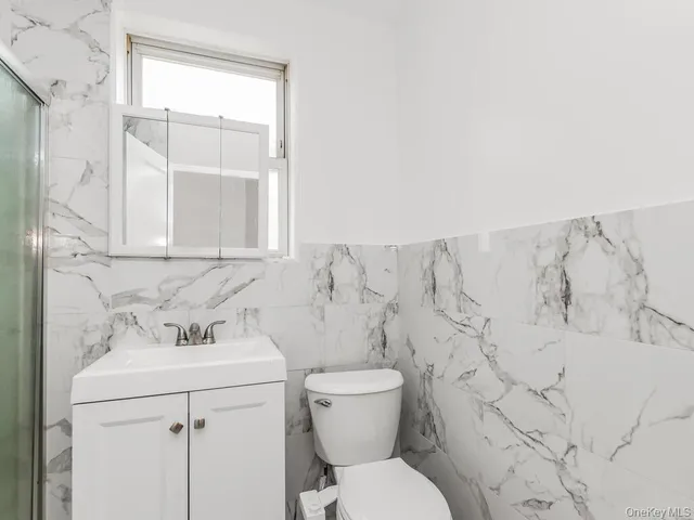 a bathroom with a sink mirror vanity and toilet