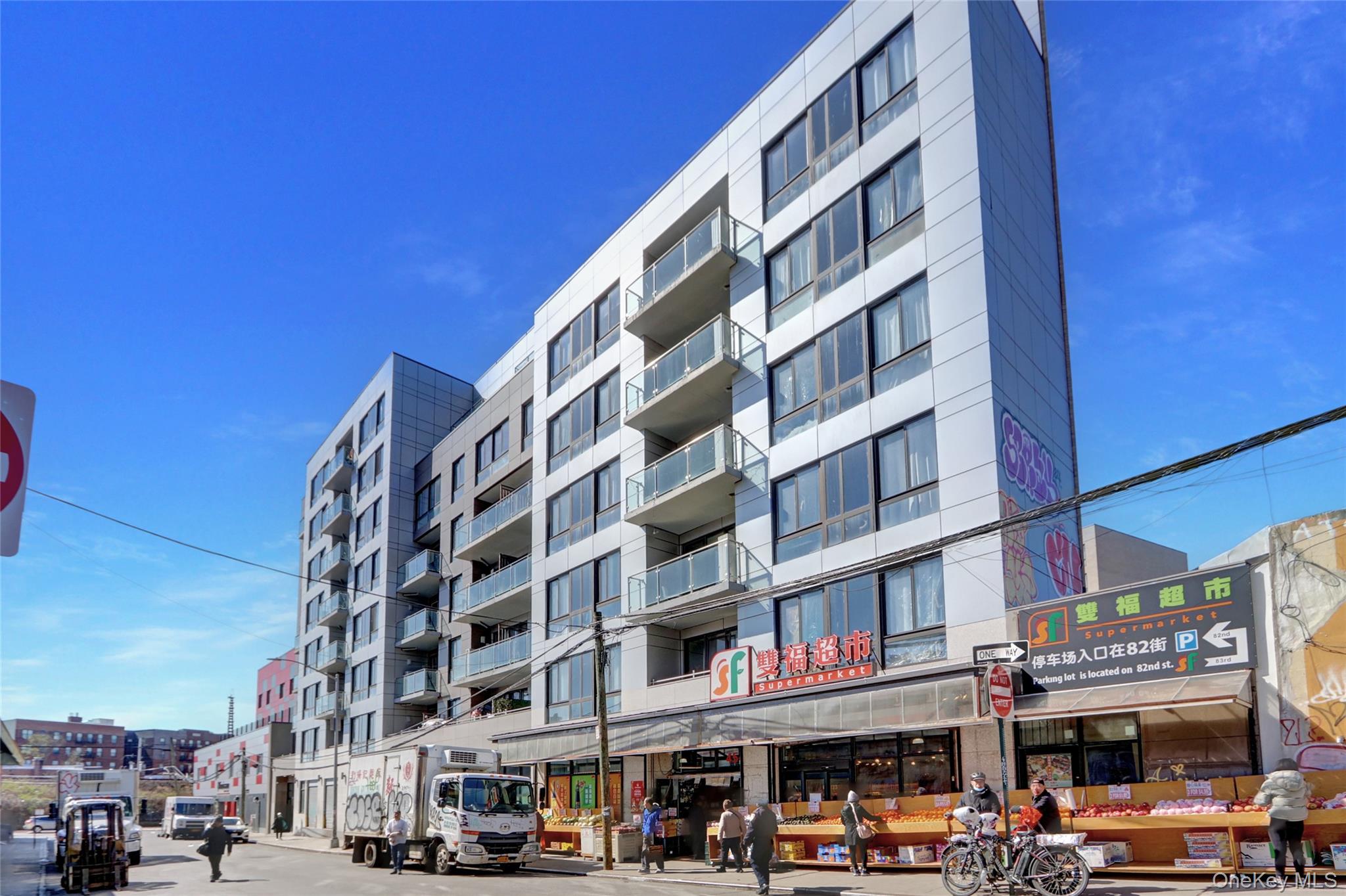 45-16 83rd Street, Unit E2J Queens, NY 11373 - Photo 1 of 15 a front view of a building with lot of cars and trees