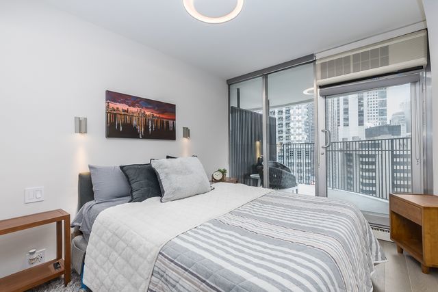 300 North State Street, Unit 2512 Chicago, IL 60654 - Photo 11 of 17 a bedroom with a large bed and a flat tv screen