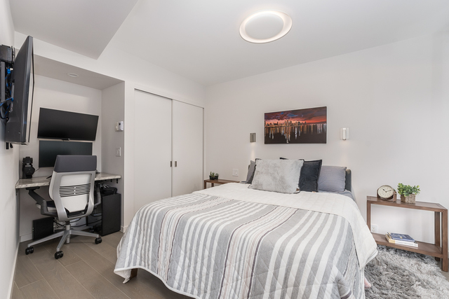 300 North State Street, Unit 2512 Chicago, IL 60654 - Photo 12 of 17 a bedroom with a bed and a flat screen tv