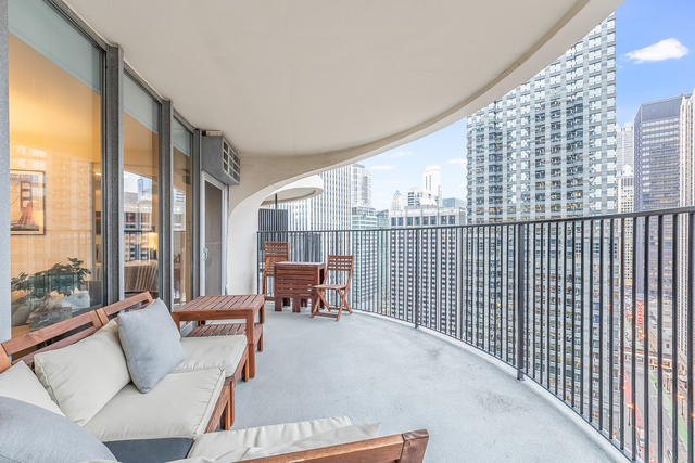 300 North State Street, Unit 2512 Chicago, IL 60654 - Photo 13 of 17 a view of balcony with couch and wooden fence