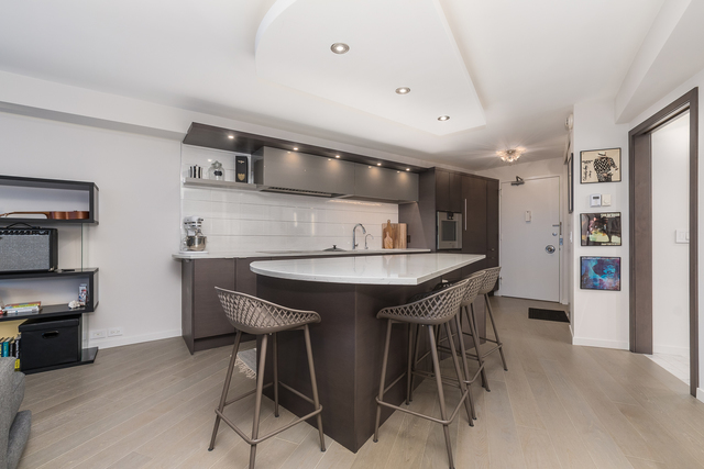 300 North State Street, Unit 2512 Chicago, IL 60654 - Photo 6 of 17 a kitchen with stainless steel appliances kitchen island granite countertop a table chairs sink and cabinets